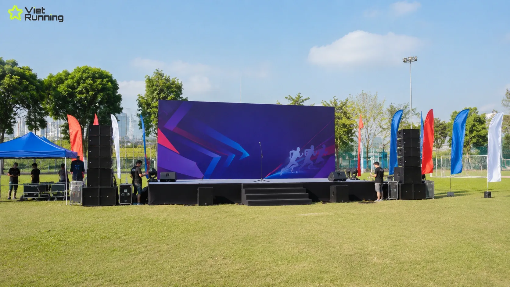 Khu vực s&acirc;n khấu, &acirc;m thanh v&agrave; backdrop cho hội thao doanh nghiệp ngo&agrave;i trời
